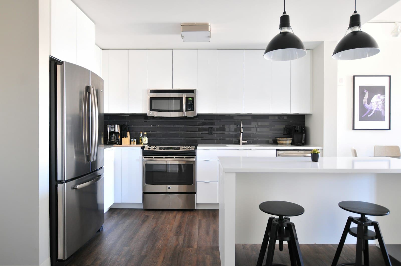 Modern kitchen with white cabinets and a dark tile backsplash